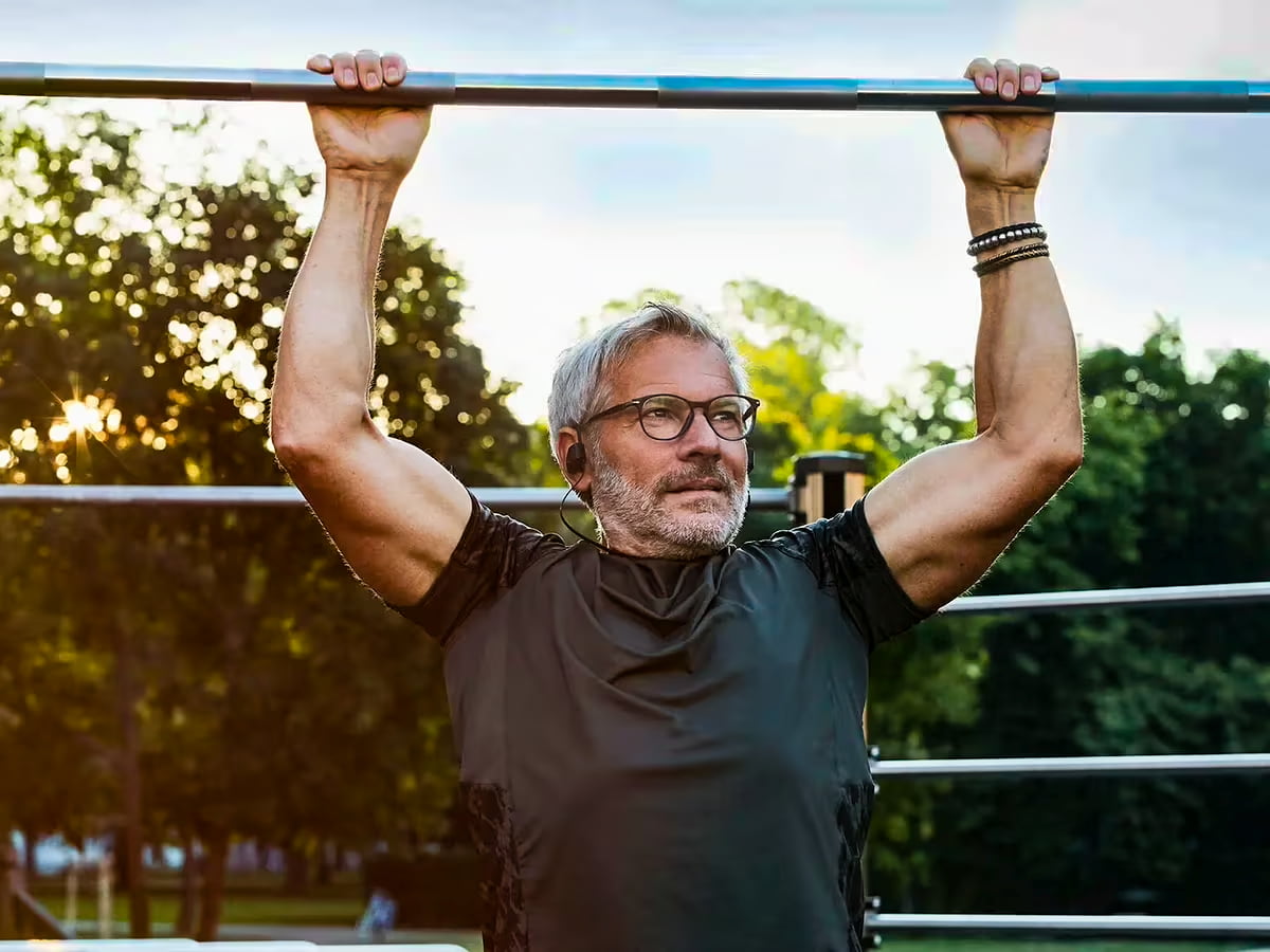 Hombre entrenando dominadas en un parque